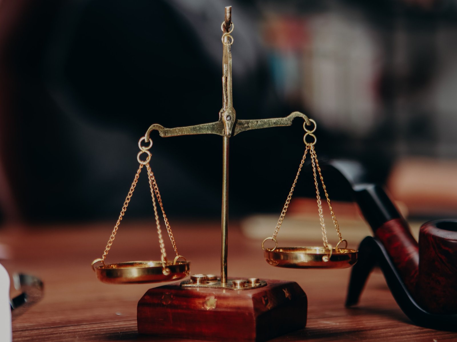 Balance de justice en laiton sur le bureau d'un juriste : la protection juridique finance les frais nécessaires pour faire valoir ses droits